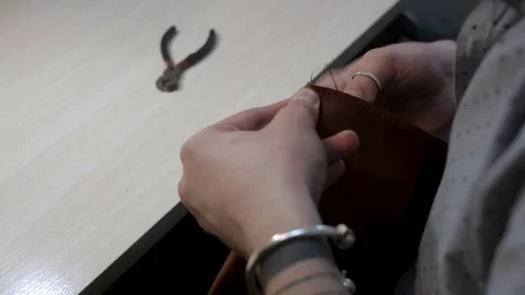 Man create a brown leather wallet handmade with a needle, thread and pliers 스톡 동영상 82055827