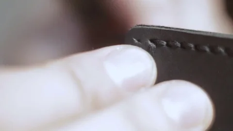 Man creates a black leather wallet with his own hands with a needle, thread a Stock Footage 82055854