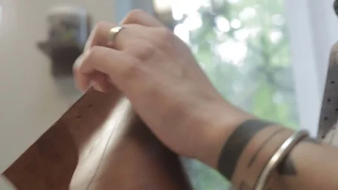 Man creates a brown leather wallet with his own hands with a needle, thread a 스톡 동영상 82055873