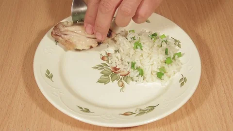 Man creates dishes portion from chicken wings with rice Stock Footage 70993960