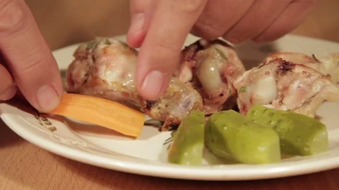 Man creates dishes portion from chicken wings with vegetables Stock Footage 71016551