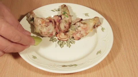 Man creates dishes portion from chicken wings with vegetables Stock Footage 71016623