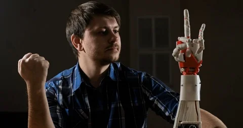 Man creates movement for mechanical plastic arm. Cybernetic robotic arm. Robots Stock Footage 85354981