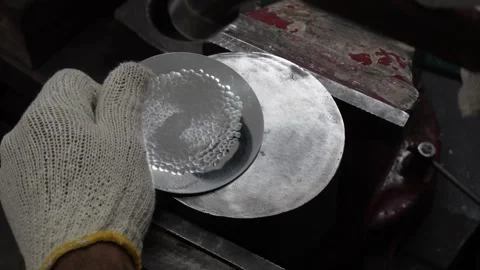 A man creating a hammering texture on a steel plate in workshop wearing a g.. Stock Footage 244741439