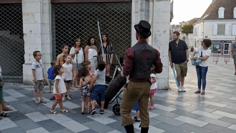 Man creating massive soap bubbles in front of children in the town center 스톡 동영상 111932414