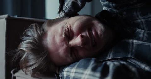A man cries and lies on the sofa covering himself with his hands at home Stock Footage 305788892