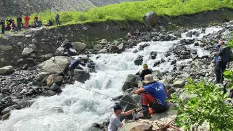 A man crosses a stormy river on a vertically fixed railing Stock-Footage 158666925