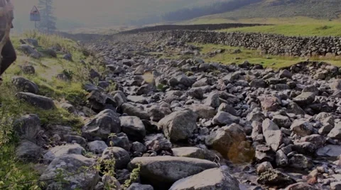 Man crosses a stream from left to right Stock Footage 41980108
