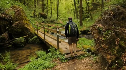 Man crossing bridge in the forest Stock Footage 39383282