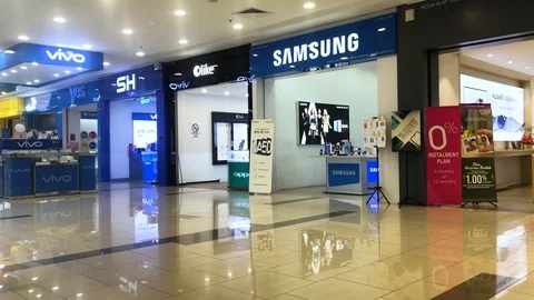 Man crossing in front of  various cellphone brand at shopping district 스톡 동영상 111738553
