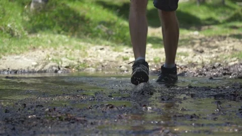 Man crossing mountain stream on rocks, Italy Видео 335680600