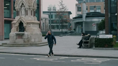 Man crossing the road while holding phone to his ear Stock Footage 130979156