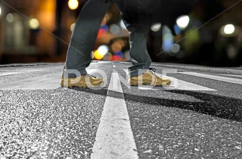 Man crossing street at night Stock Photos