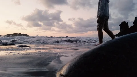 Man crossing waves on sunset Benijo beach Video stock 122366419