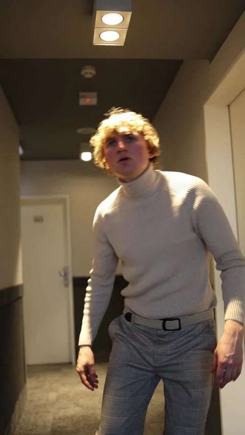 A man crouches slightly, his expression filled with concern and focus. His wide  Video stock 292515743