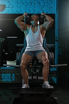 Man crouches in Smith machine Stock Photos
