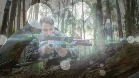 Man crouching behind fallen log in pine forest, showing tech crossbow HUD and Video stock 327900993