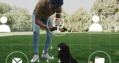 Man crouching tapping smartphone screen revealing technology overlays for Stock Footage 316120439