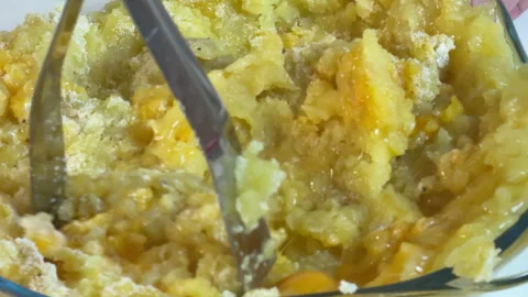 A man crushes boiled potatoes to make potato patties Stock Footage 303126536