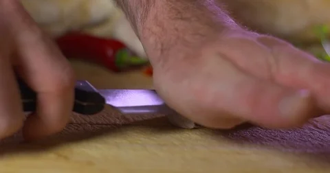 Man crushes garlic clove with flat knife blade. Slow motion Stock Footage