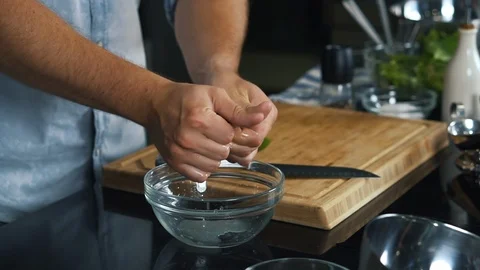 Man crushes lime with his hands, juice drips into bowl, shot in studio, cooking Stock Footage 125730978