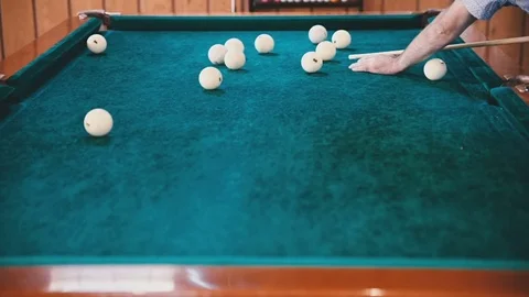 Man with a cue in his hands aims at the ball Stock Footage 81544480