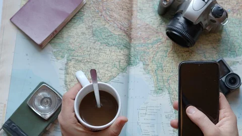 Man with a cup of coffee and smart phone  looking at a map Stock Footage 127686522
