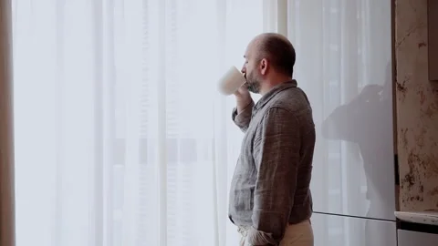 A man with a cup of coffee in the morning by the window. Stock Footage 276757492