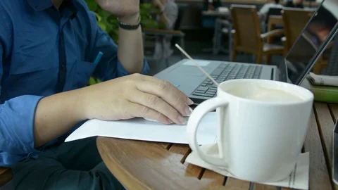 Man with a cup of coffee working on his laptop Stock Footage 83782837