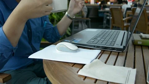 Man with a cup of coffee working on his laptop Stock Footage 83783426