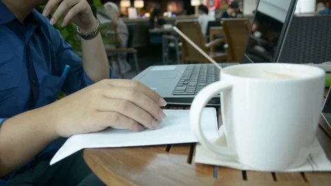 Man with a cup of coffee working on his laptop Stock Footage 83787275