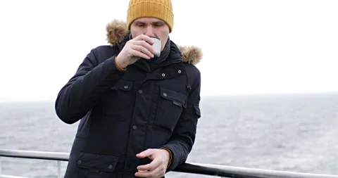 Man with a cup of hot drink on the deck of cruise ship 스톡 동영상 299586112