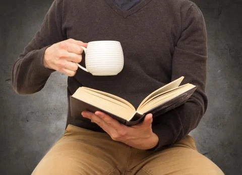 Man with cup reading book Stock Photos