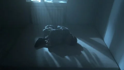 Man curled up on mattress in empty room, lost everything and doesnt know how to Stock Footage 312111453