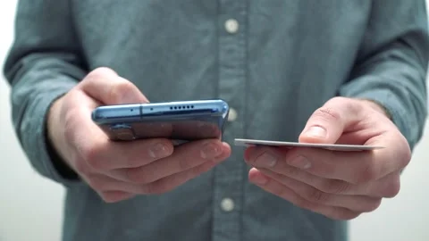 Man customer using a credit card and a smartphone to make an online payment 库存影片 147953285