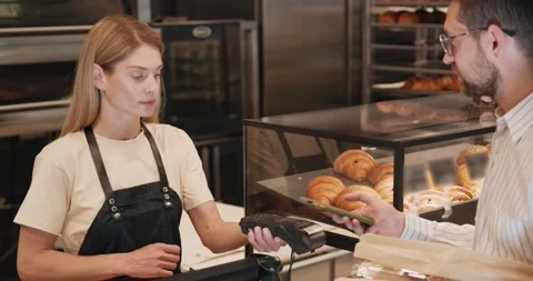 Man customer using a smartphone paying for order in a bakery shop Stock Footage 220148385