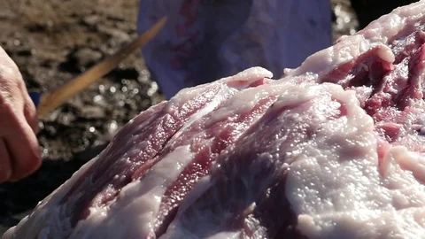 Man cut with an ax, ribs and meat from the spine of the pig that you h Stock Footage 70691005