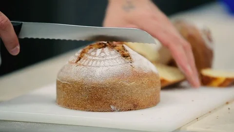 The man cut the bread into a two pieces Stock Footage 77668569