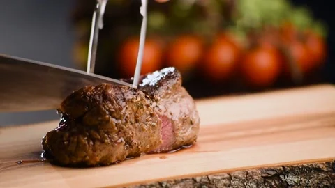 Man cut grilled steak with a sharp knife on wooden board Video stock 150400334
