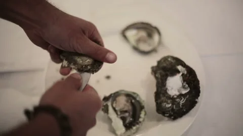 Man cut up oysters in the kitchen in the evening in a restaurant Stock Footage 52966435
