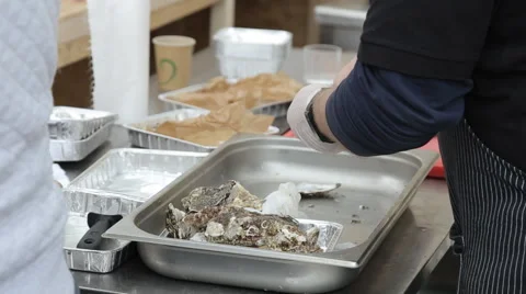Man cut up oysters in the kitchen in the evening in a restaurant Stock Footage 64107294