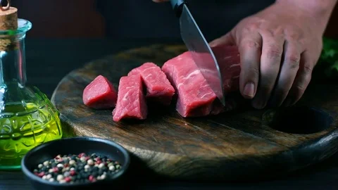 Man cut raw beef on steak pieces Stock Footage 82064909