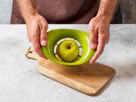 Man cuts apple with slicer. Stock Photos