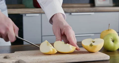 A man cuts an apple into slices Stock Footage 250820338