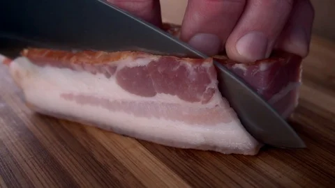 A man cuts bacon with a chef's knife Stock Footage 102217968