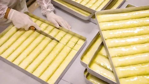 Man cuts the baklava dough on the tray Stock Footage 82041653