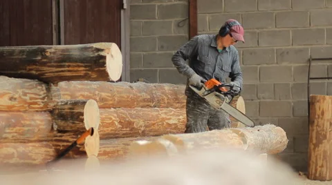 Man cuts off beam chainsaw for future home. Man cuts off beam chainsaw for Stock Footage 65205395
