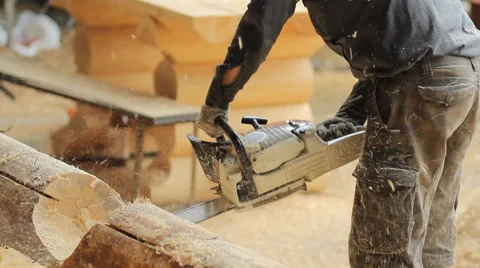 Man cuts off beam chainsaw for future home. Construction works with a wooden Stock Footage 65205490