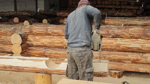 Man cuts off beam chainsaw for future home. Man cuts off beam chainsaw for Stock Footage 65205580