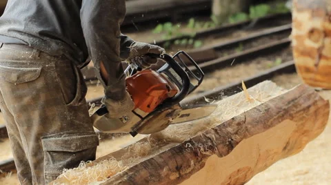 Man cuts off beam chainsaw for future home. Construction works with a wooden Stock Footage 65316519